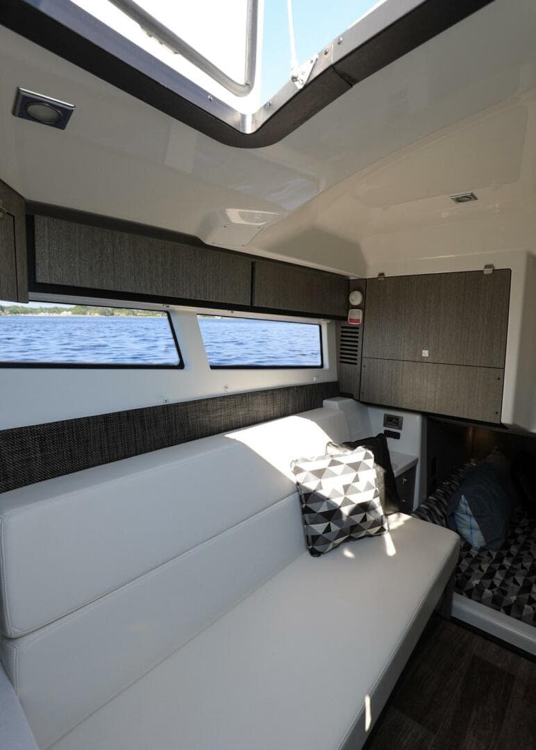 Interior of 2023 Monterey 385 Super Sport yacht with modern seating and windows.