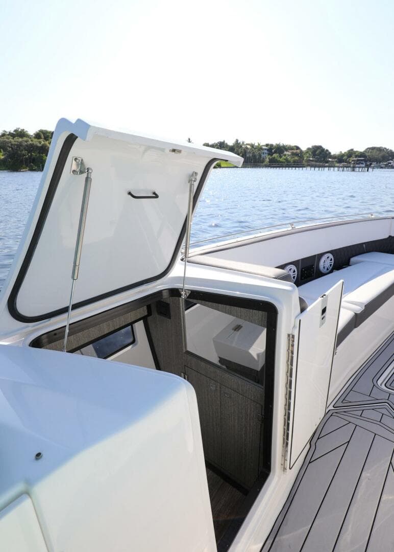 2023 Monterey 385 Super Sport boat with open hatch, docked on a sunny day.