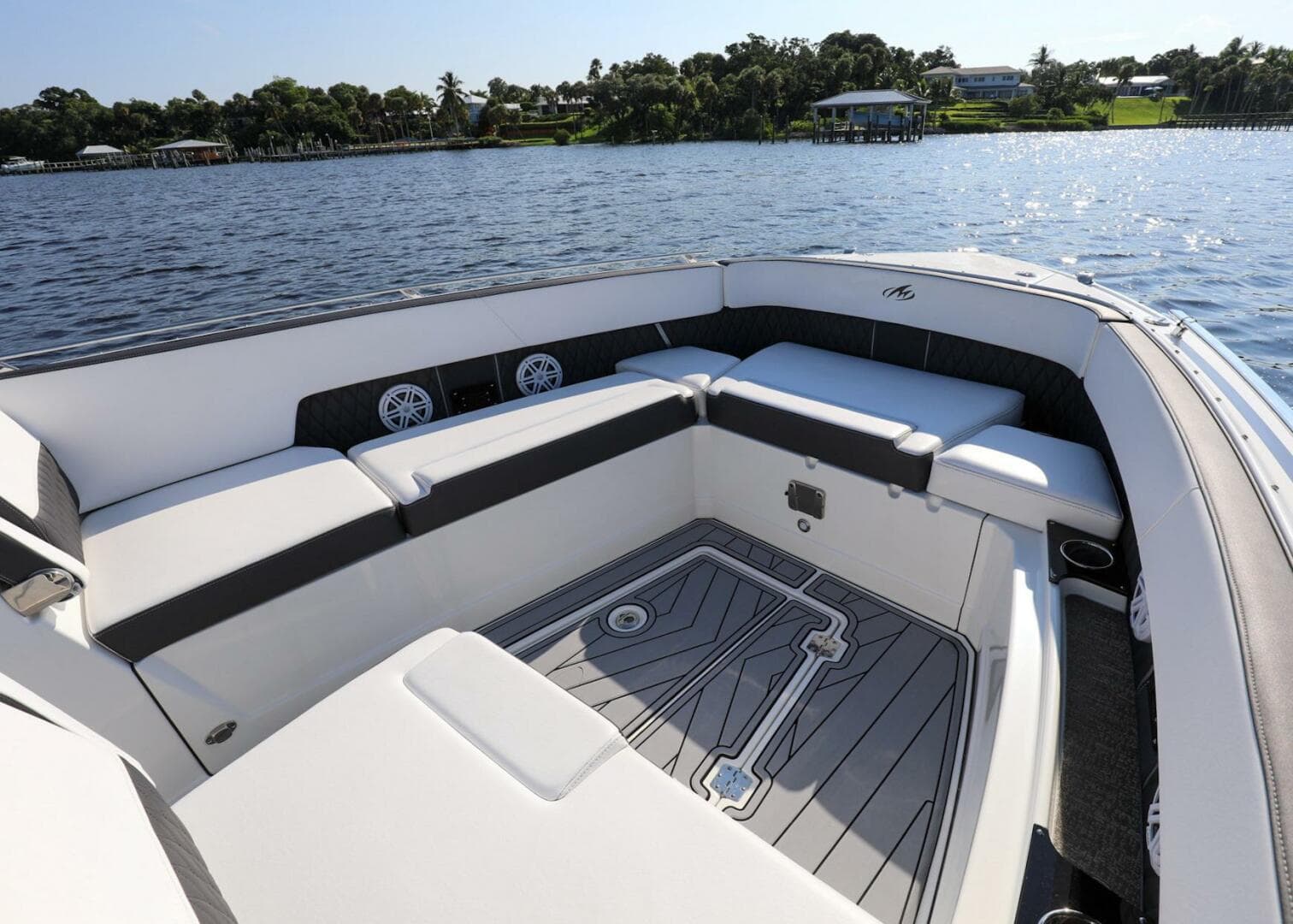 2023 Monterey 385 Super Sport boat interior with spacious seating, on a serene water backdrop.