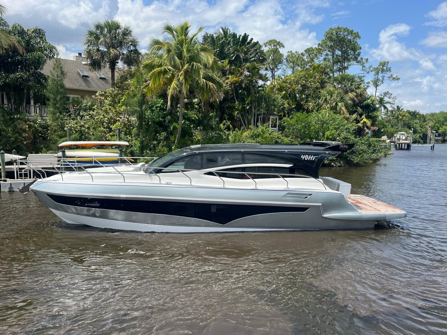 Luxury 2025 Real 40 HT yacht on a scenic river with lush greenery.