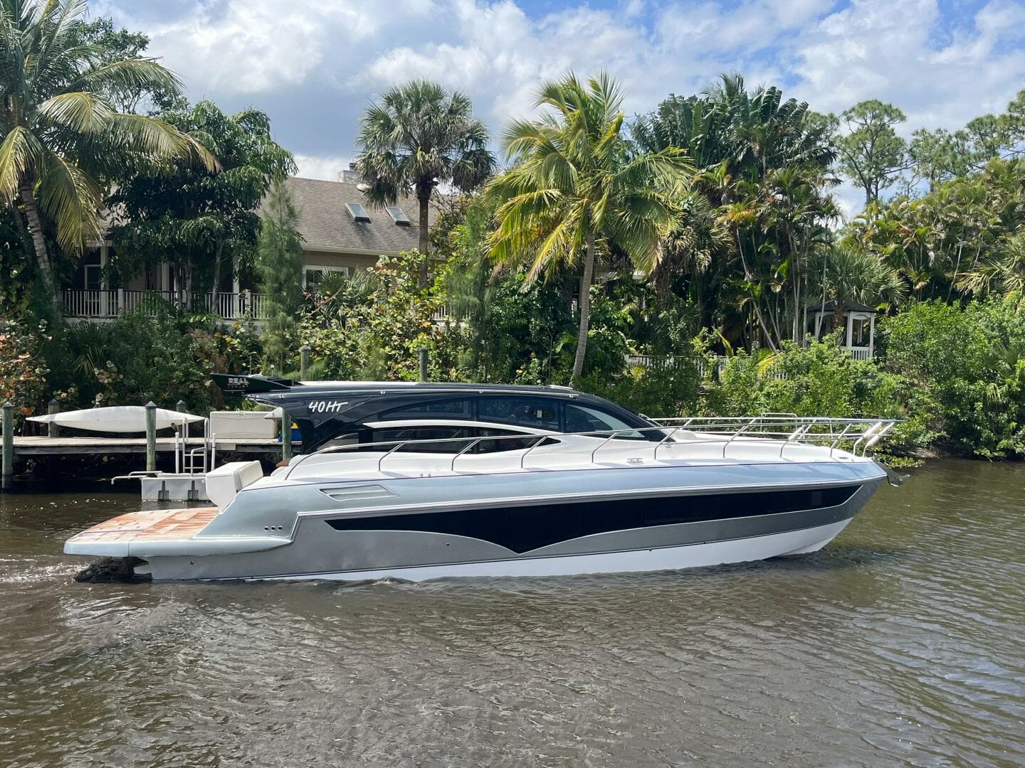 2025 Real 40 HT Luxury yacht cruising on a scenic river with lush greenery.