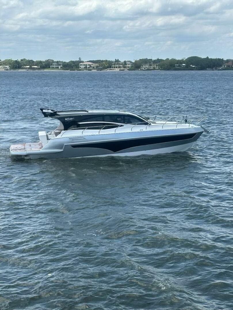 2025 Real 40 HT Luxury yacht cruising on a calm sea under a cloudy sky.