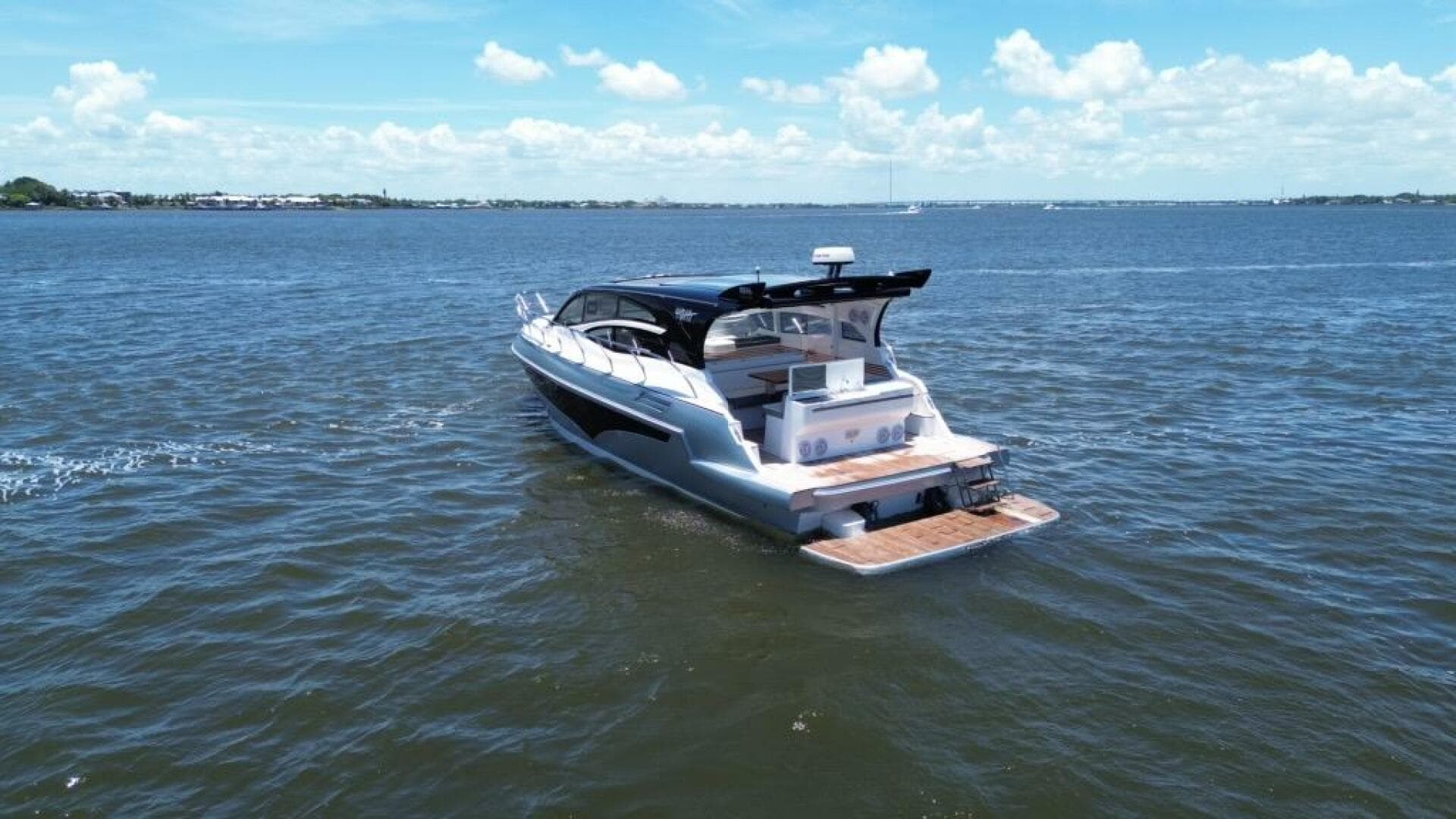 Luxury yacht Real 40 HT 2025 cruising on open water under a clear blue sky.