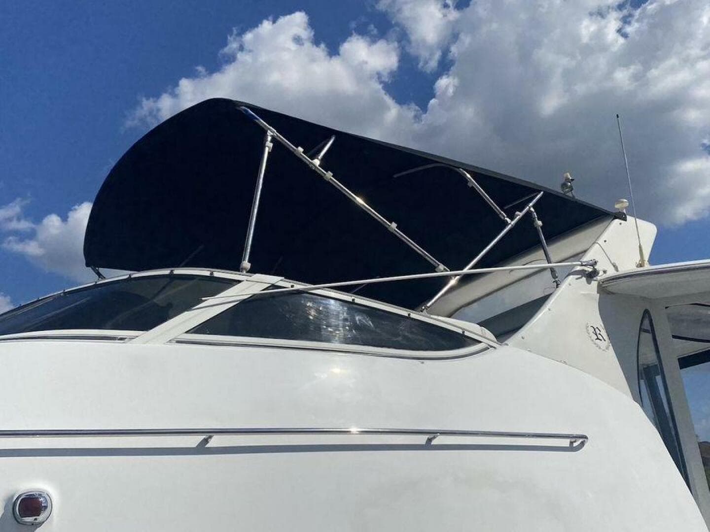 2000 Carver 396 Motor Yacht with canopy against a cloudy sky.