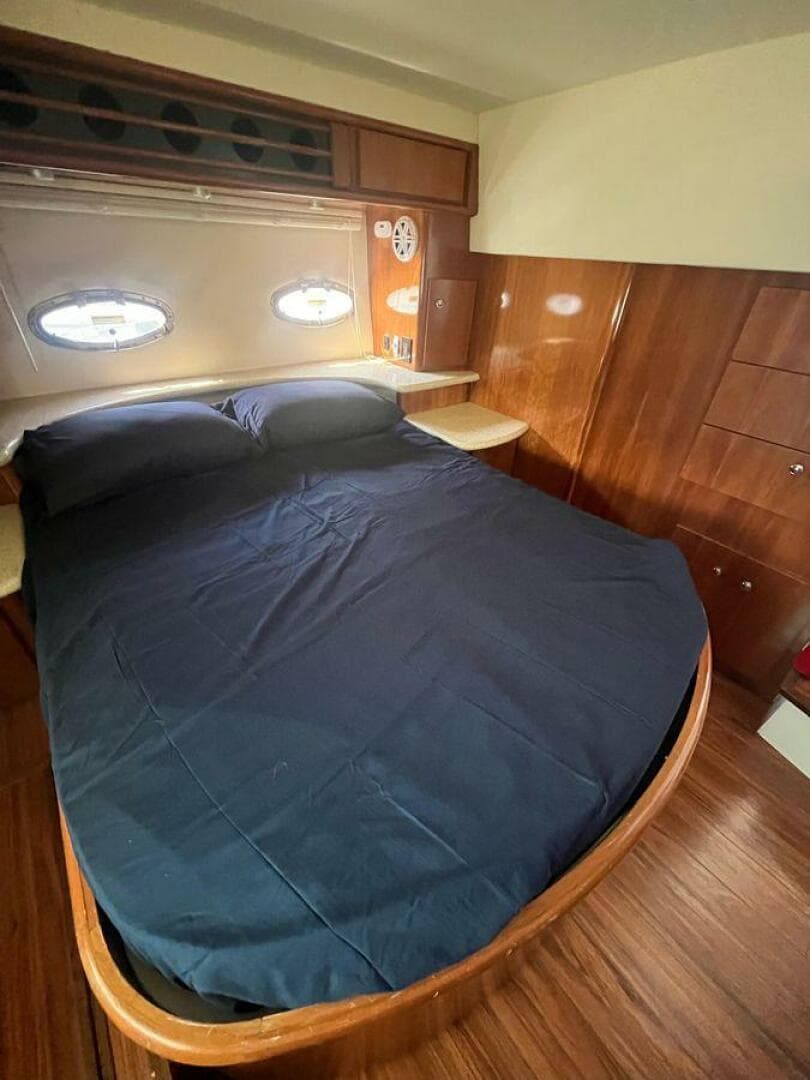2000 Carver 396 Motor Yacht bedroom with wood paneling and porthole windows.