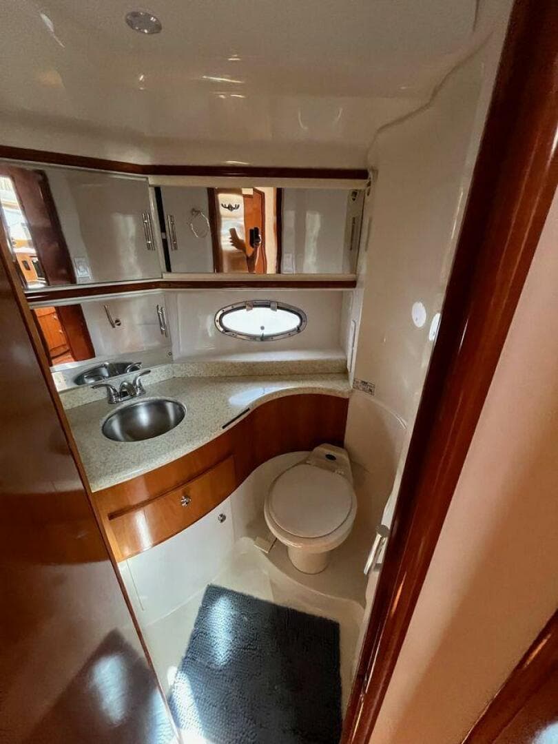 2000 Carver 396 Motor Yacht bathroom with sink, toilet, and porthole window.