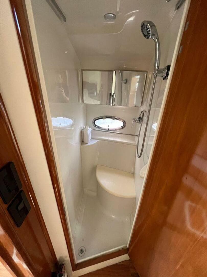 Compact shower in 2000 Carver 396 Motor Yacht with oval window and modern fixtures.