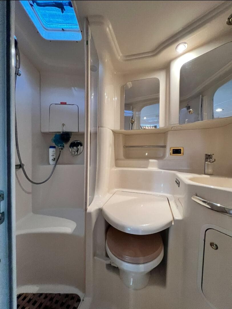 2001 Sea Ray 380 Sundancer bathroom with shower, toilet, and storage cabinets.