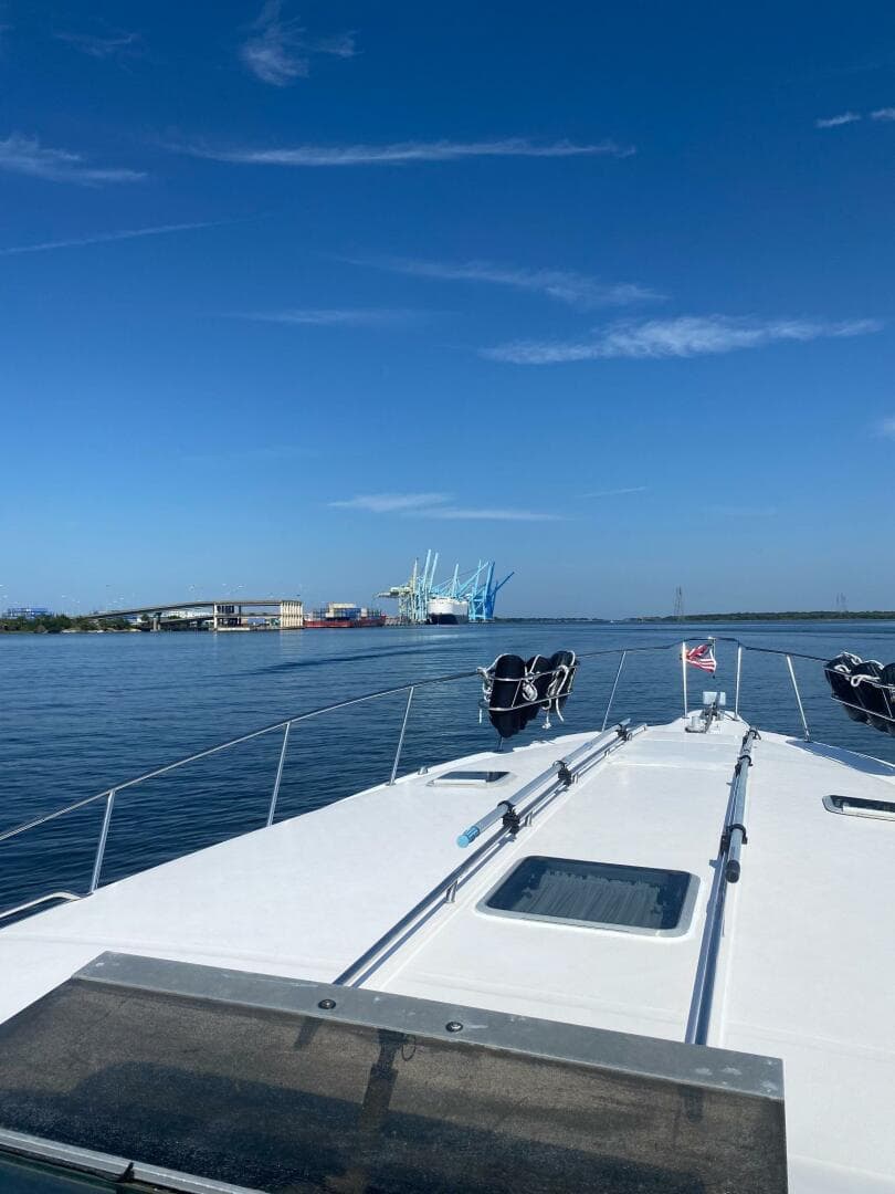 1993 Sea Ray 440 Sundancer cruising on calm waters under a clear blue sky.