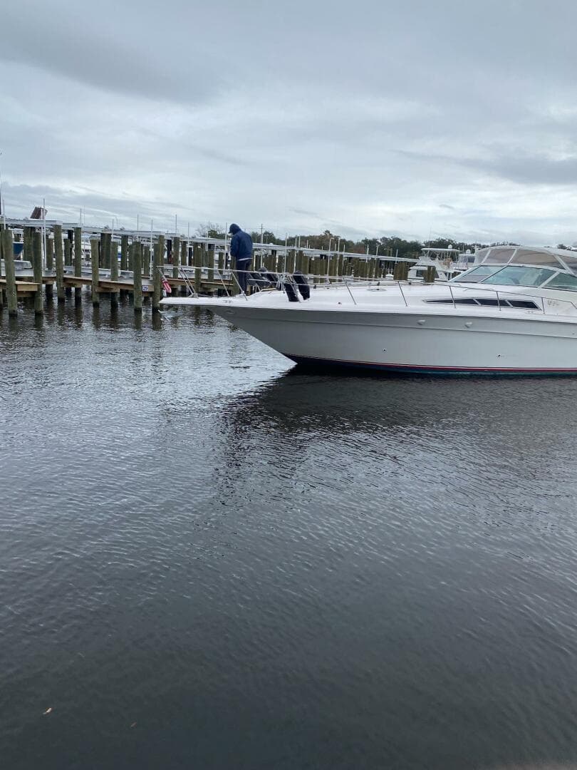 1993 Sea Ray 440 Sundancer yacht docked at a marina on a cloudy day.