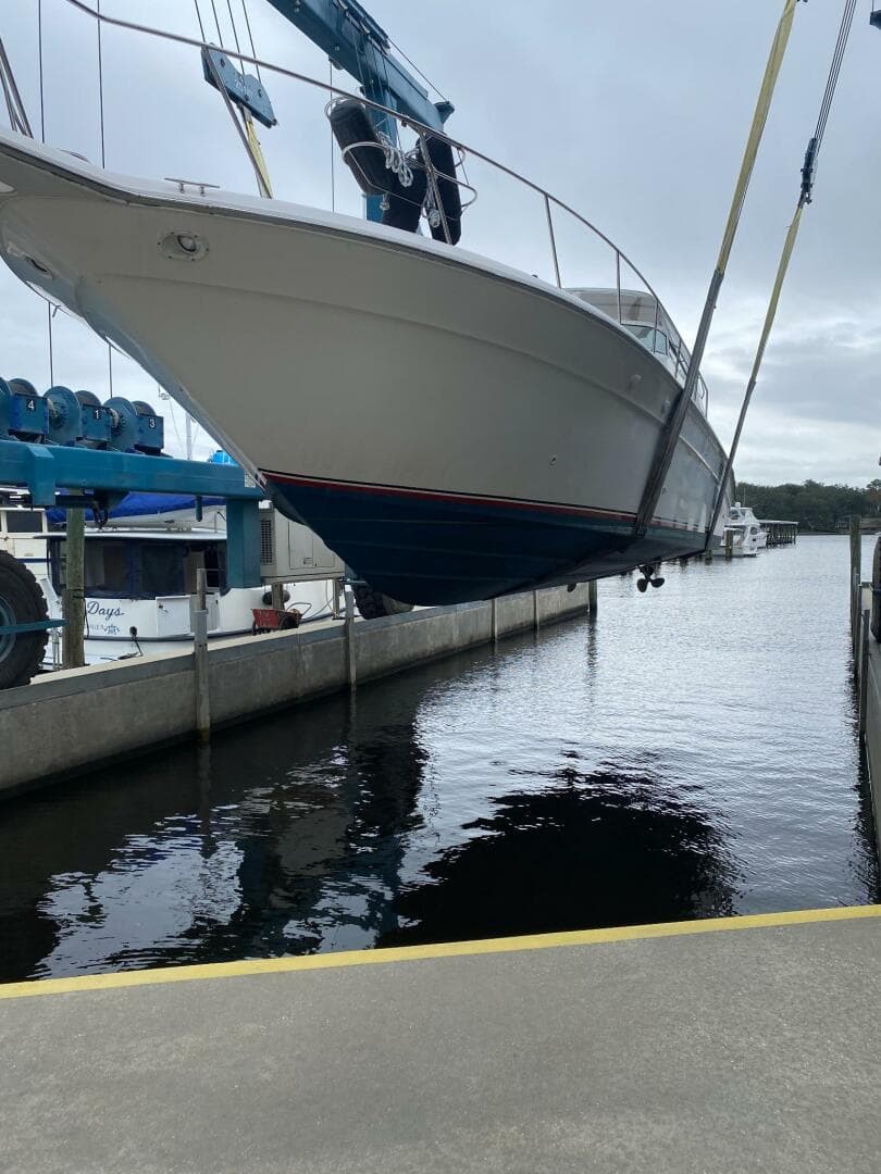 1993 Sea Ray 440 Sundancer yacht being lifted at a marina.