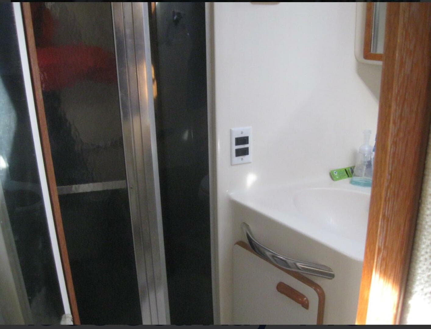 Bathroom interior of 1993 Sea Ray 440 Sundancer yacht, featuring sink and shower.