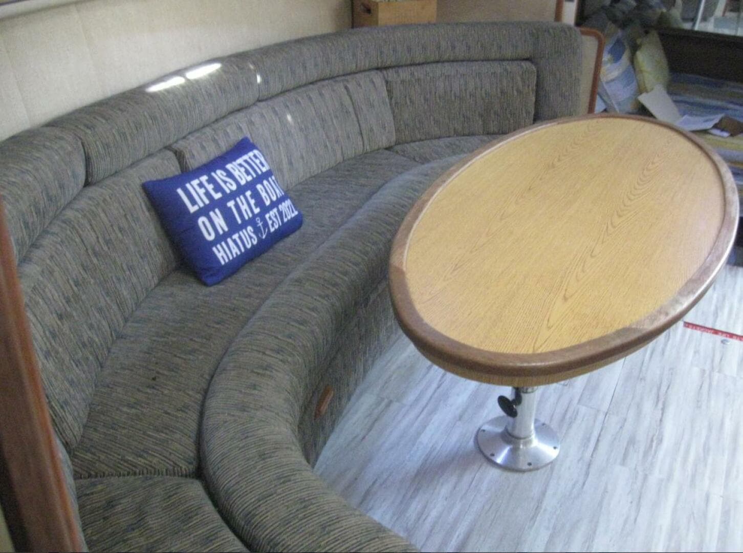 Interior of 1993 Sea Ray 440 Sundancer with curved seating and wooden table.