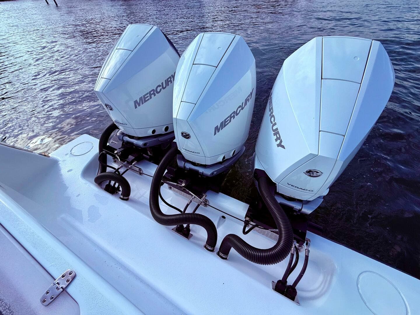 Triple Mercury outboard engines on 2024 Contender 39 ST boat, docked on water.