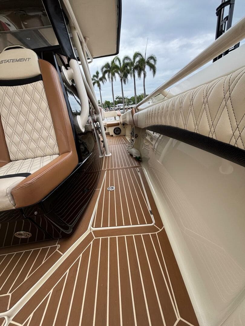 Luxurious 2013 Statement 35 Center Console boat interior with elegant seating and wood-patterned flooring.