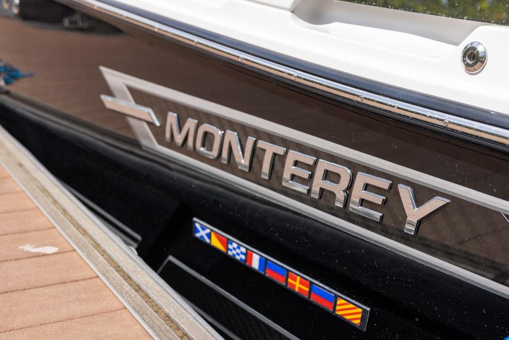 2023 Monterey 255 Super Sport boat with logo and nautical flags.