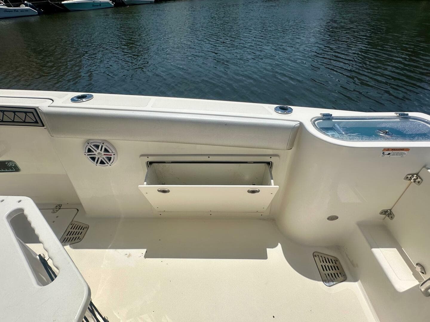 2019 Wellcraft 262 Fisherman boat interior with storage compartment and water view.
