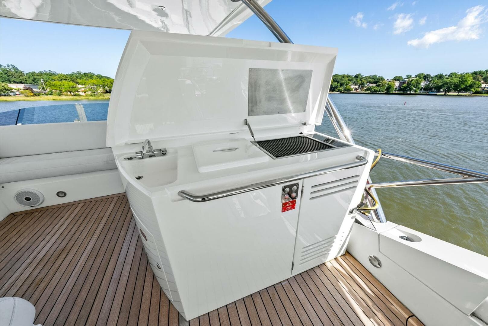 Outdoor kitchen on 2016 Sunseeker Manhattan 65 yacht, featuring grill and sink by the water.