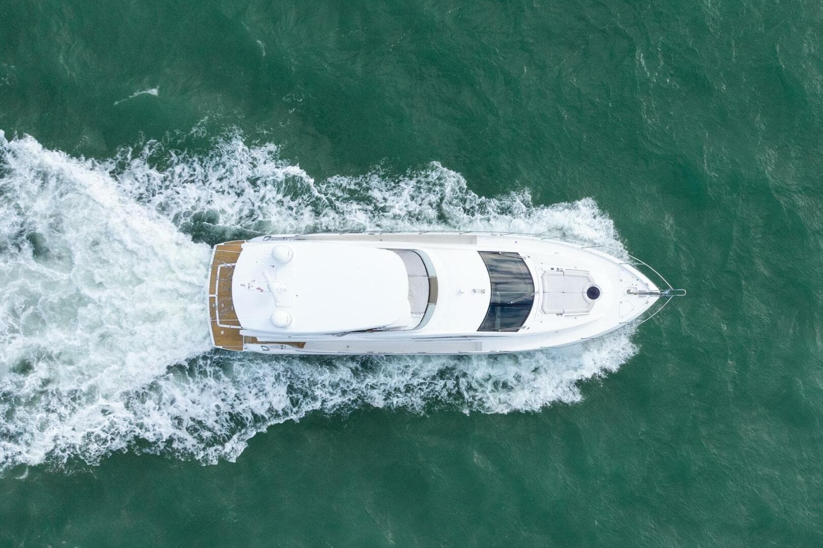 Aerial view of 2016 Sunseeker Manhattan 65 yacht cruising on the ocean.