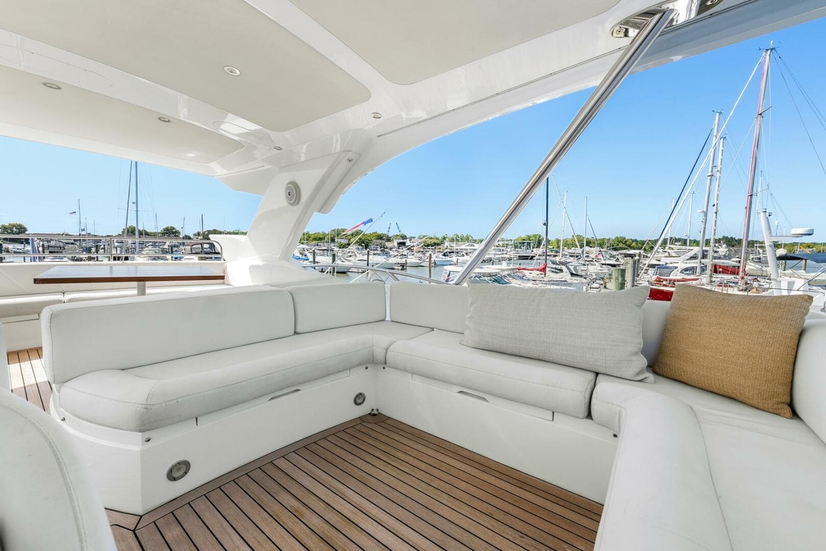 Luxurious Sunseeker Manhattan 65 yacht interior, 2016 model, featuring elegant white seating and marina view.