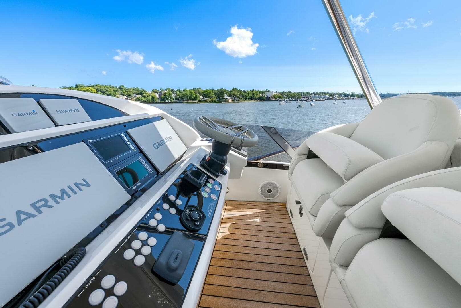 2016 Sunseeker Manhattan 65 yacht helm with Garmin navigation, overlooking serene waters.