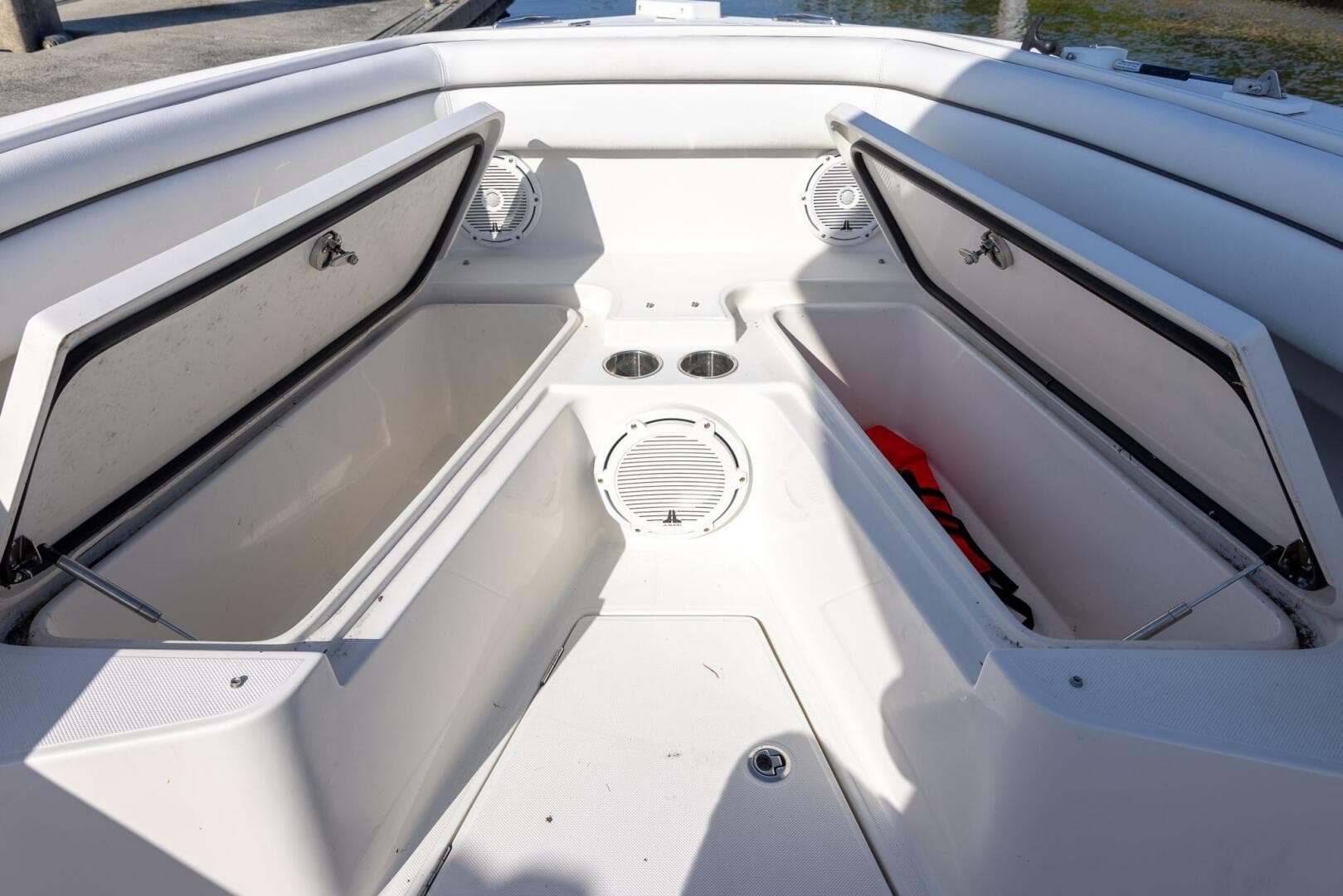 2018 Jupiter 26 FS boat interior with open storage compartments and cup holders.