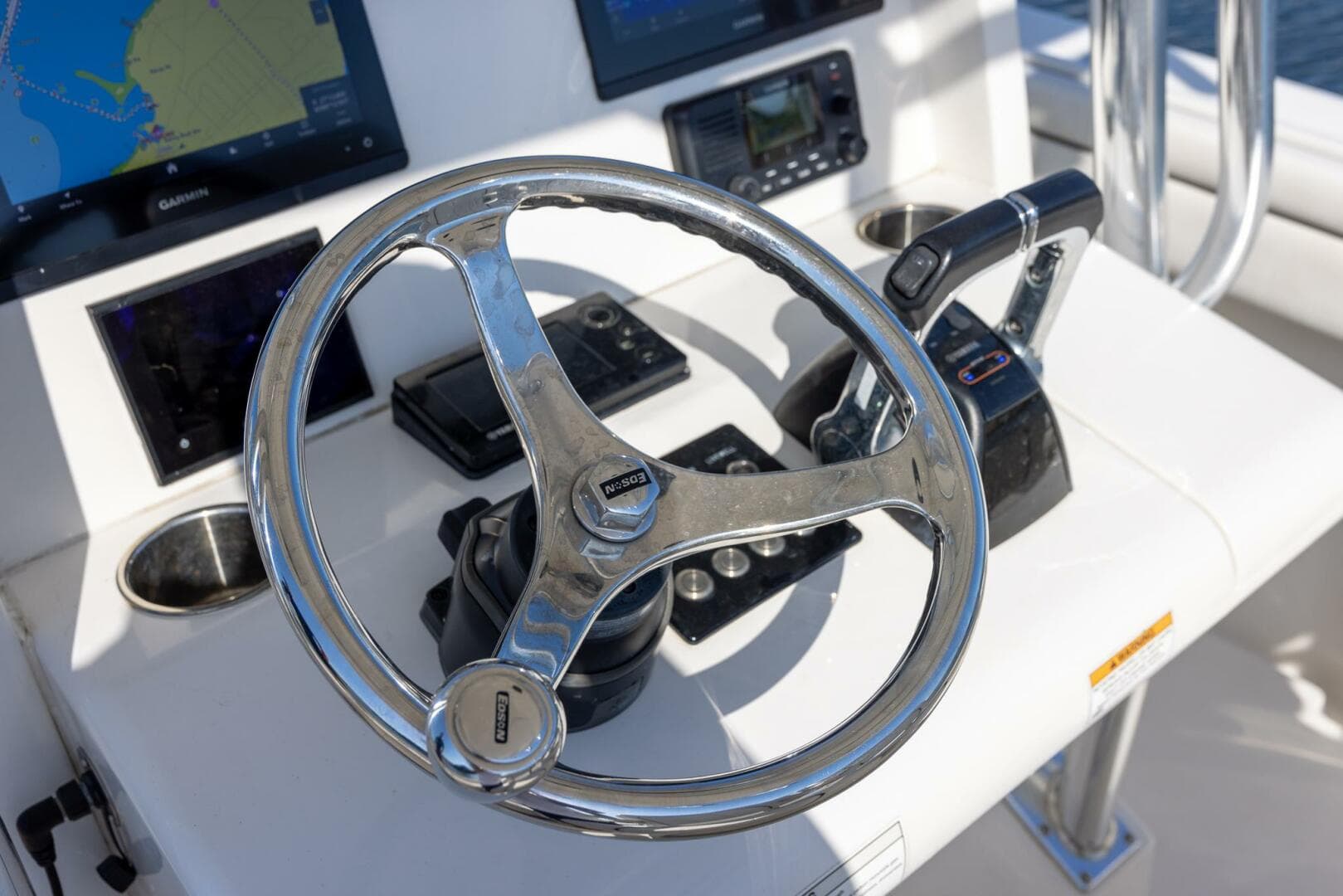 Steering wheel and controls of a 2018 Jupiter 26 FS boat cockpit.