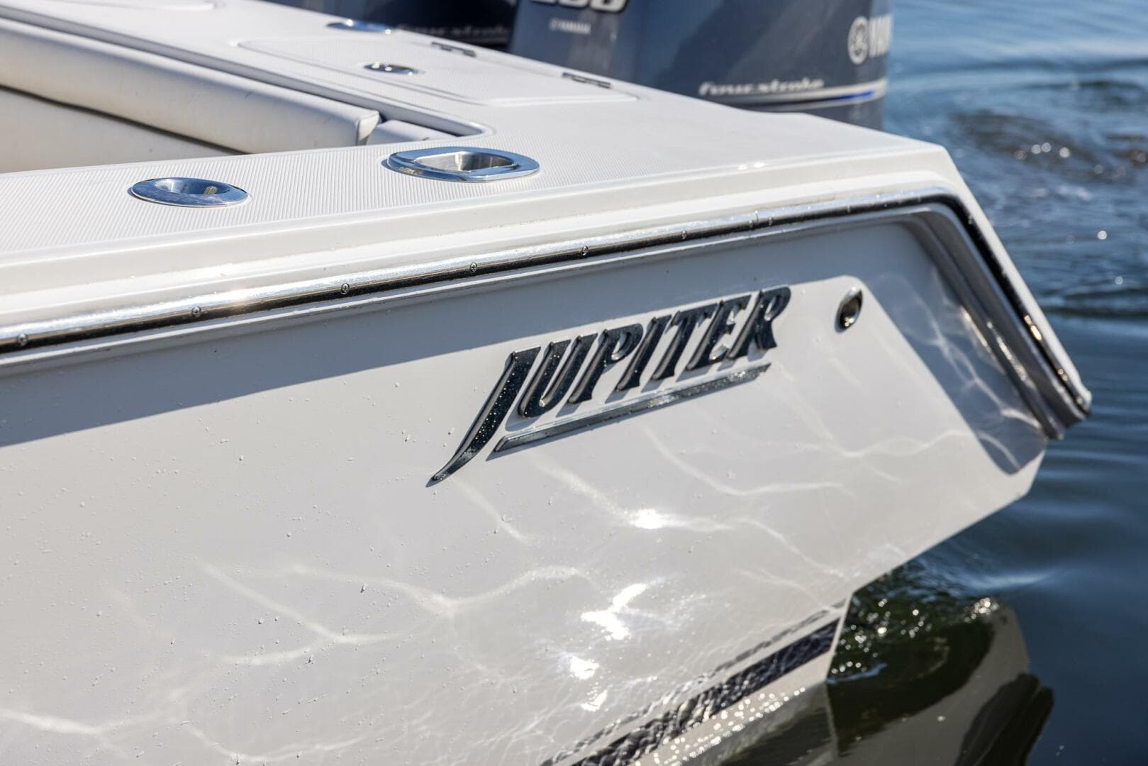 2018 Jupiter 26 FS boat, close-up of logo on sleek white hull.