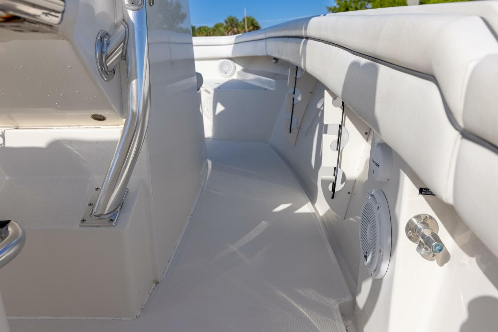 Interior view of a 2018 Jupiter 26 FS boat, featuring sleek white seating and stainless steel fixtures.