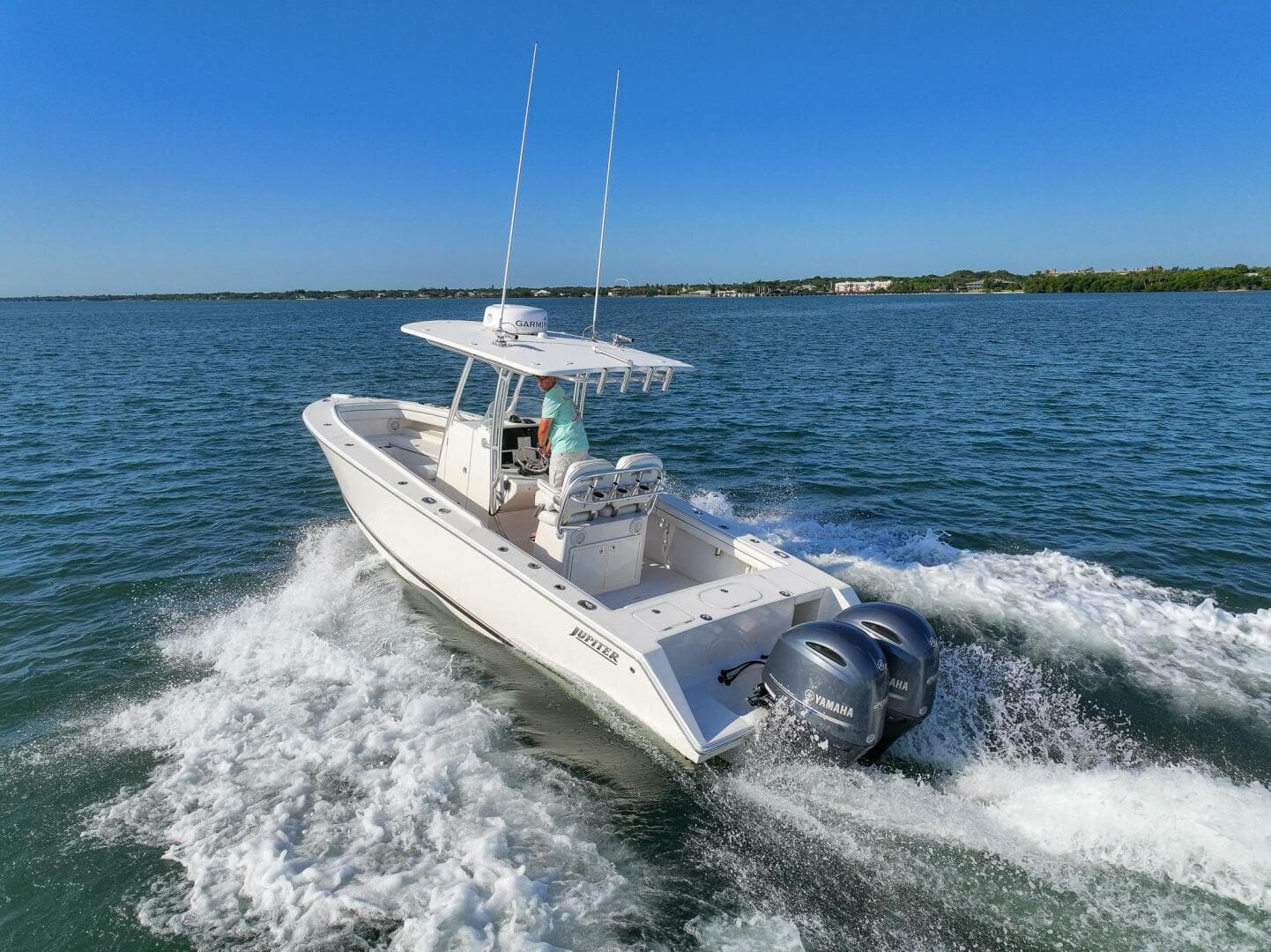 2018 Jupiter 26 FS boat cruising on open water with twin engines.