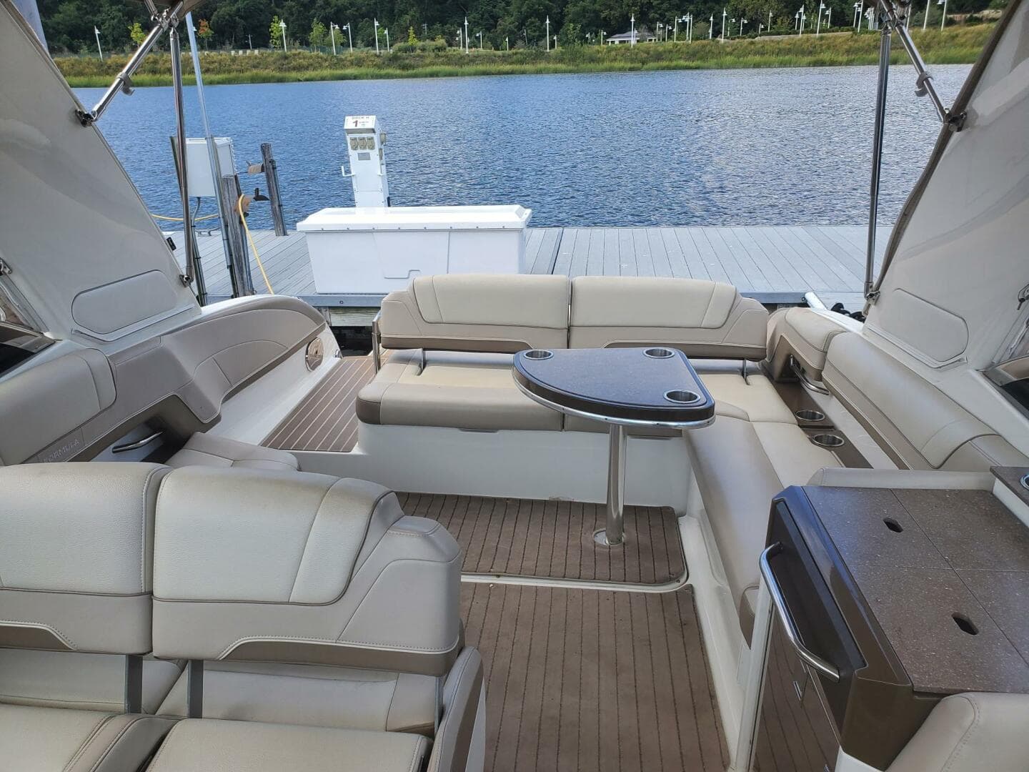 2015 Formula 330 Crossover Bowrider interior with seating and table, docked by a lake.