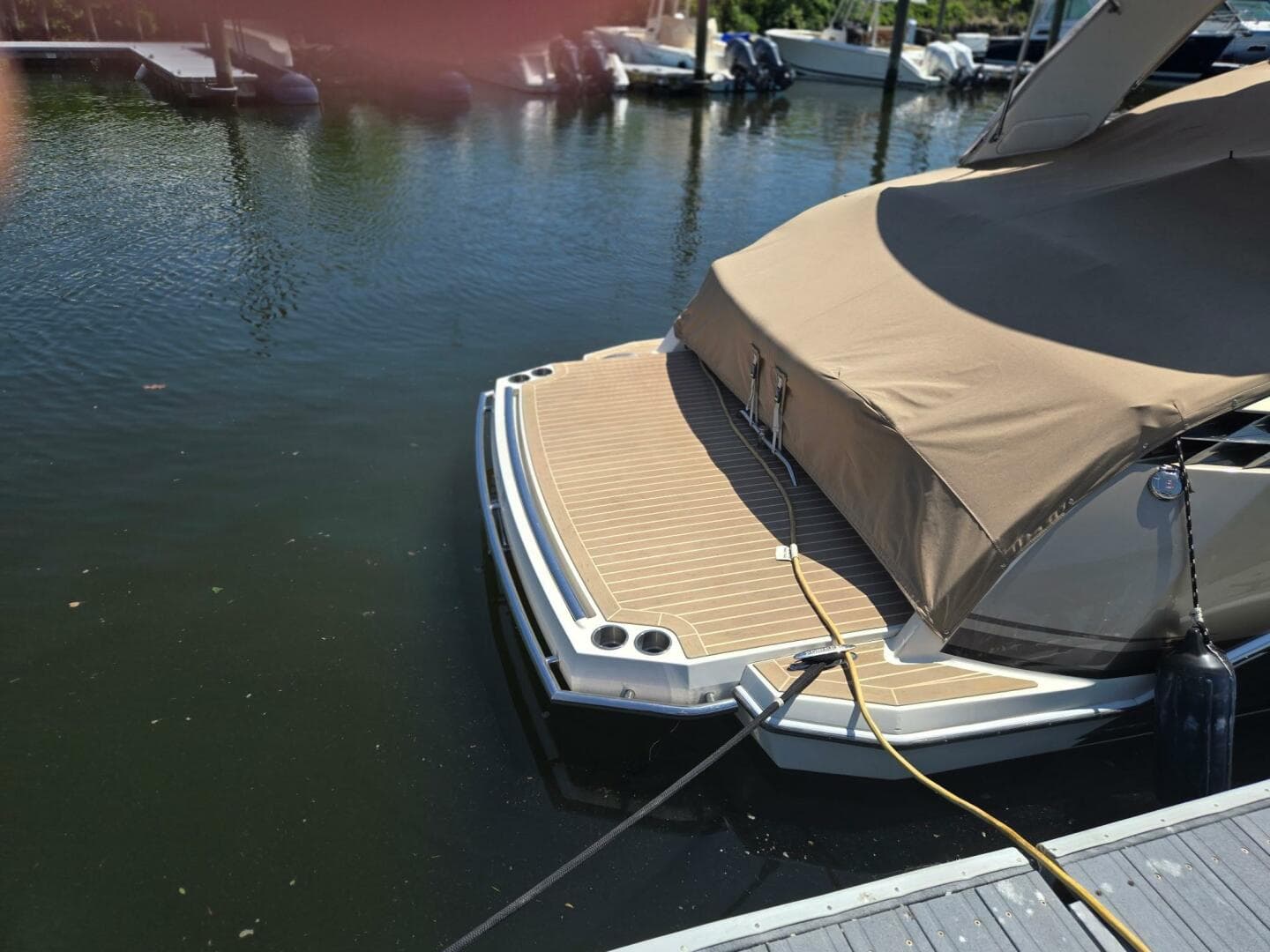 2015 Formula 330 Crossover Bowrider docked with cover, rear view.