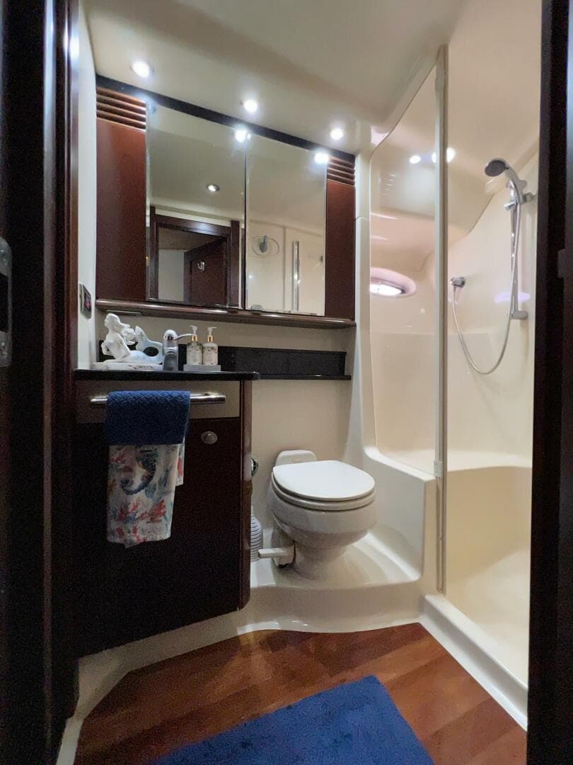 Luxurious bathroom in 2005 Sea Ray 500 Sedan Bridge yacht with shower and wooden accents.