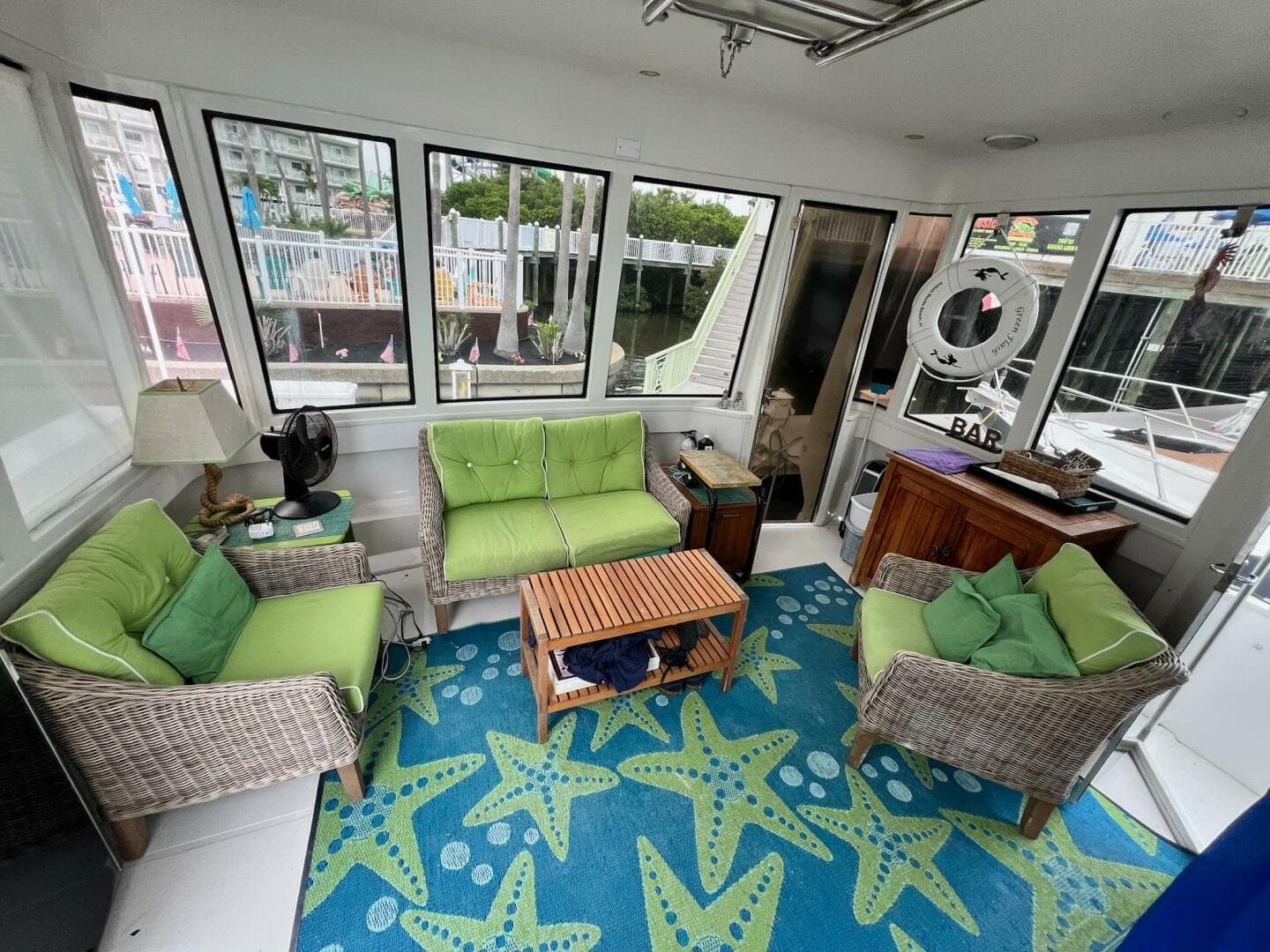 Interior of 2000 Carver 506 Motor Yacht with green seating and starfish-patterned rug.