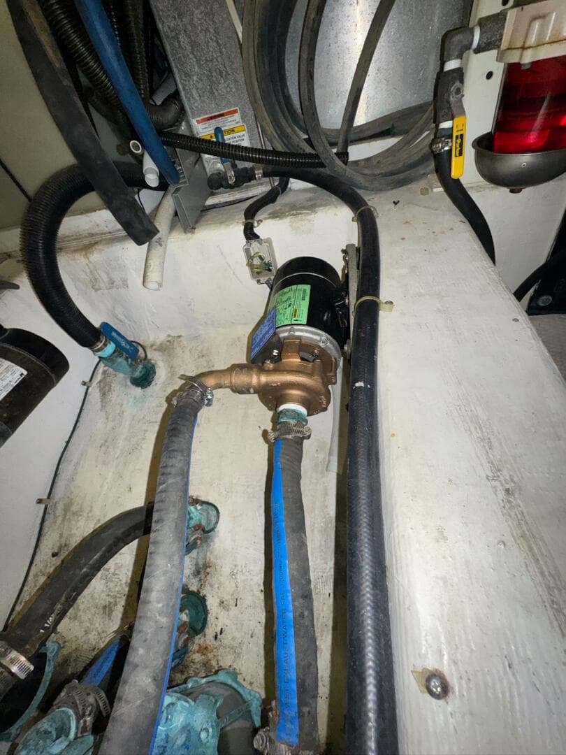 Engine room of 2000 Carver 506 Motor Yacht with visible hoses and components.