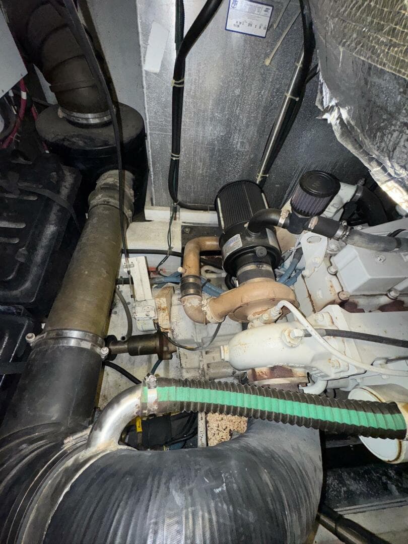 Engine room of a 2000 Carver 506 Motor Yacht, showcasing mechanical components and piping.