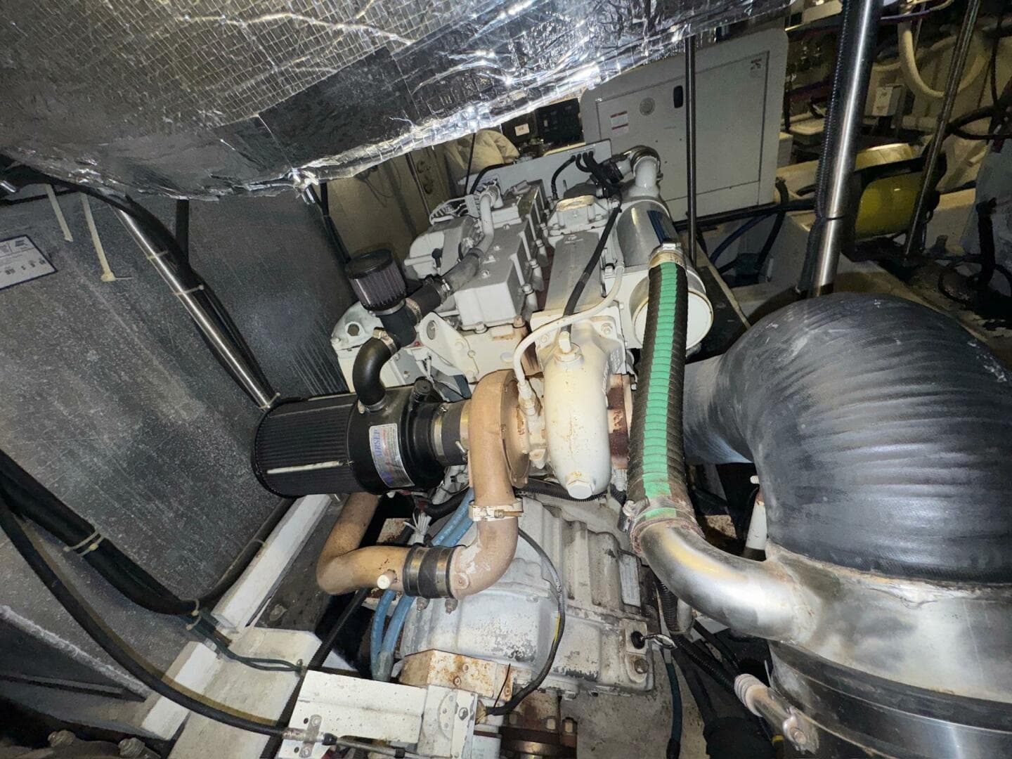 Engine room of 2000 Carver 506 Motor Yacht, showcasing mechanical components and piping.