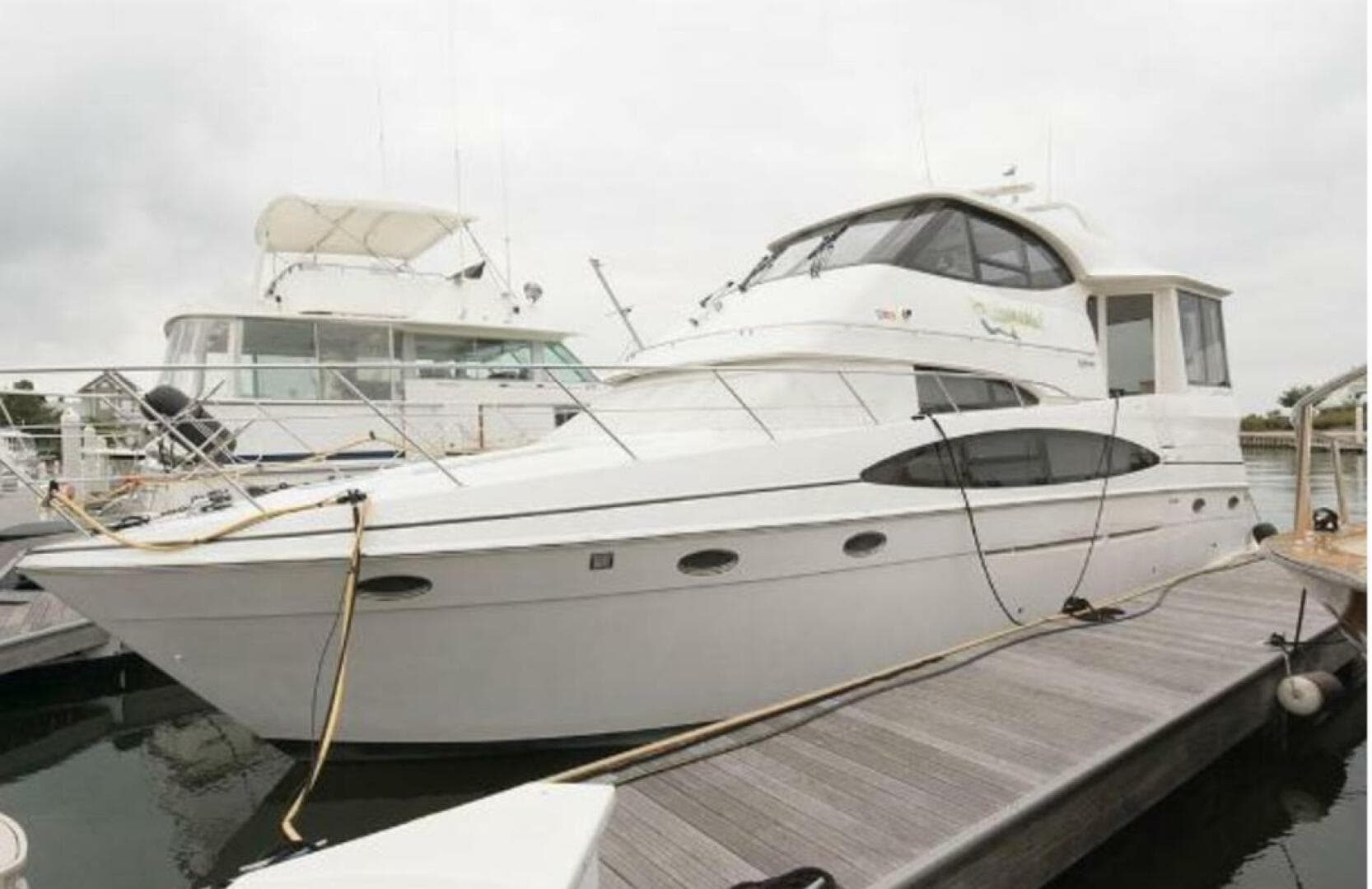 2000 Carver 506 Motor Yacht docked at marina, showcasing sleek design and spacious deck.