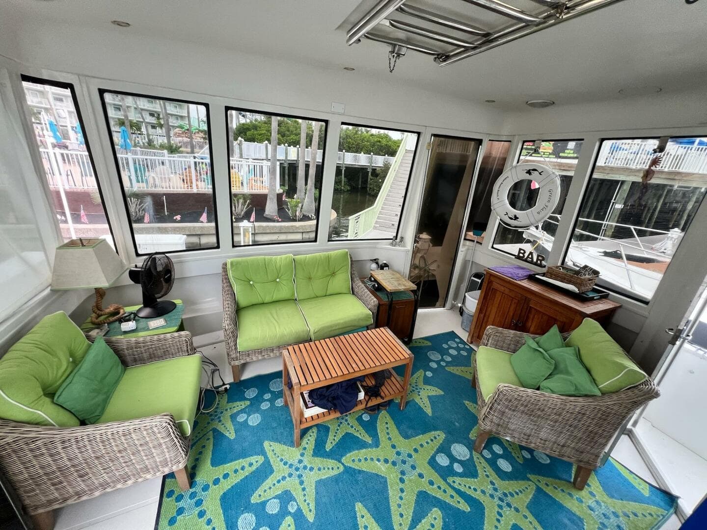 Interior of 2000 Carver 506 Motor Yacht with green seating and starfish-patterned rug.