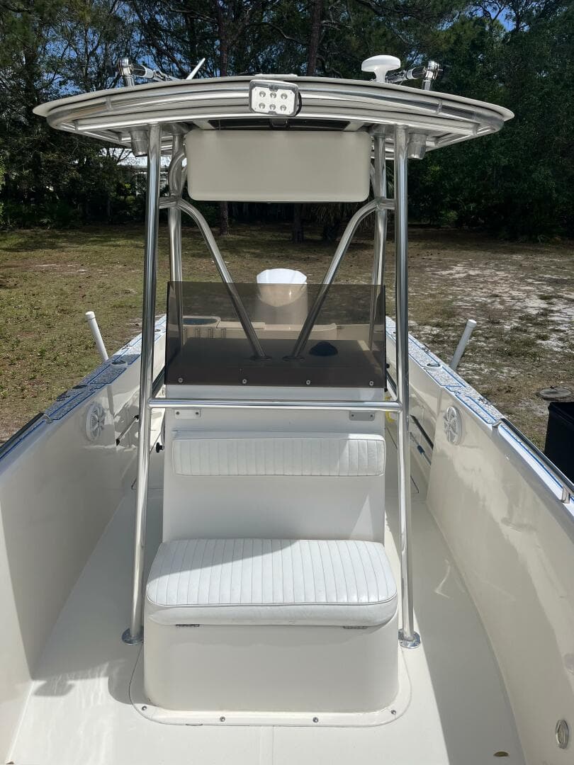 1998 Blue Fin 25 Center Console boat with T-top and seating, parked outdoors.