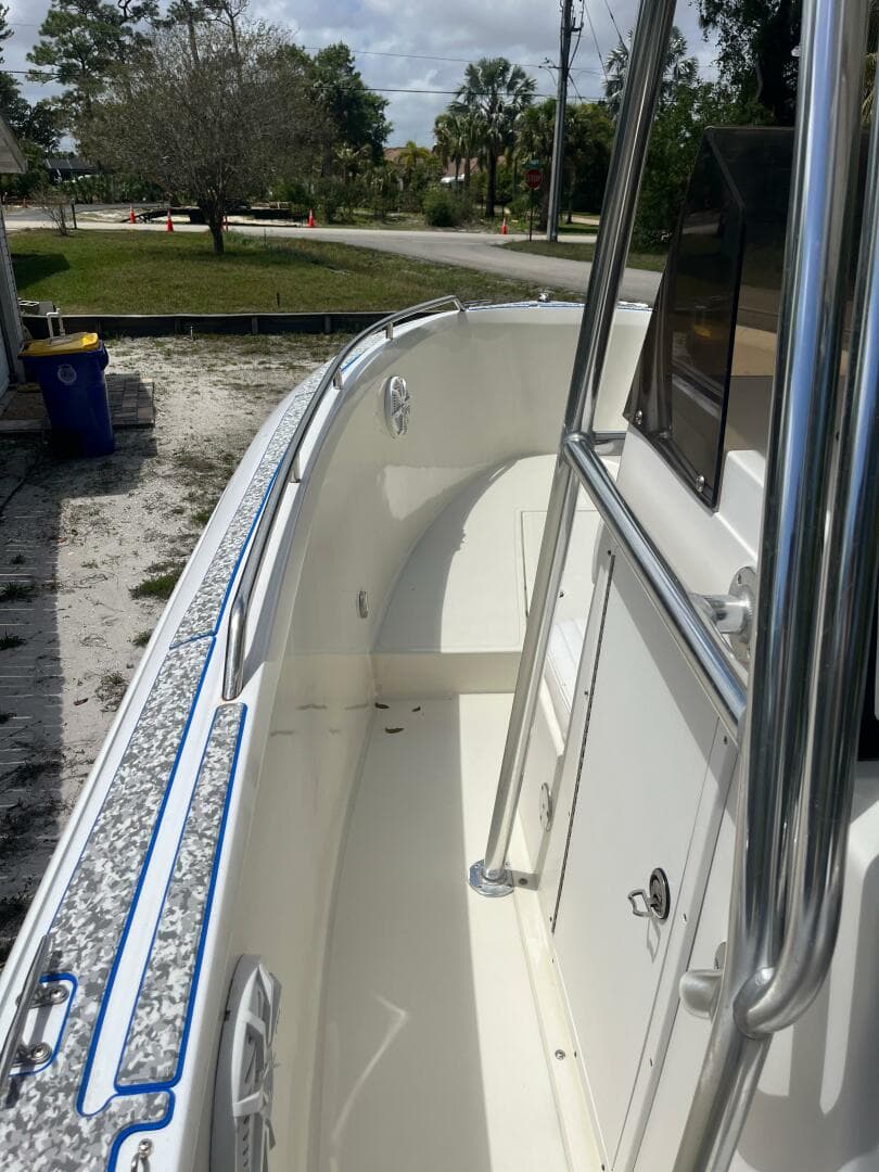 1998 Blue Fin 25 Center Console boat, white interior, stainless steel railings, outdoor setting.