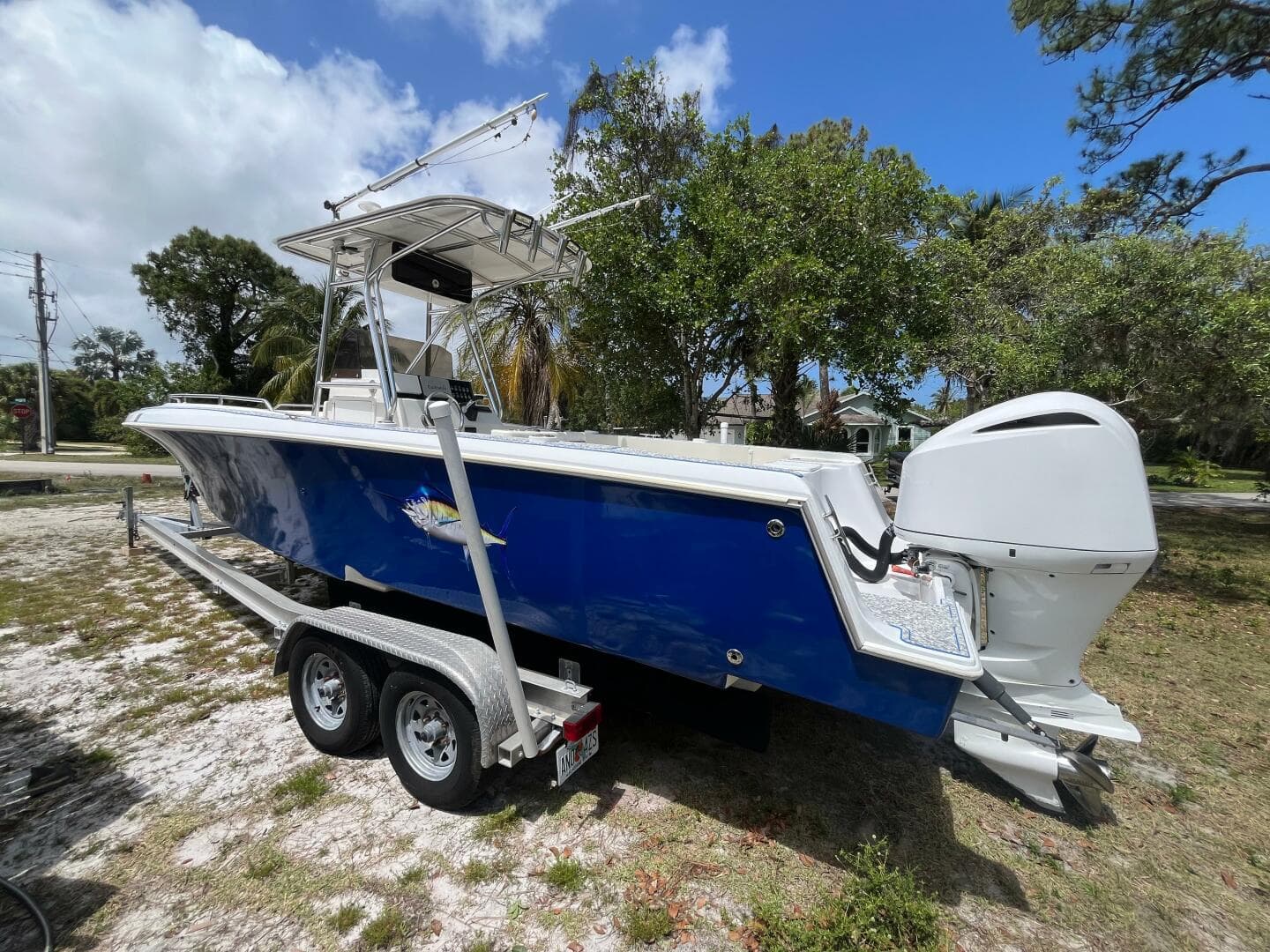 1998 Blue Fin 25 Center Console boat on trailer, parked outdoors.