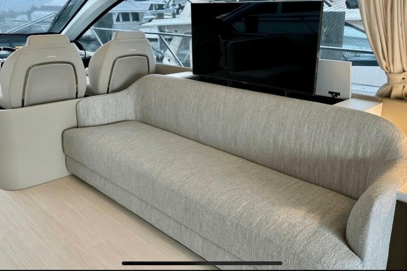 Luxurious interior of 2023 Azimut Fly 53 yacht with modern sofa and helm seats.