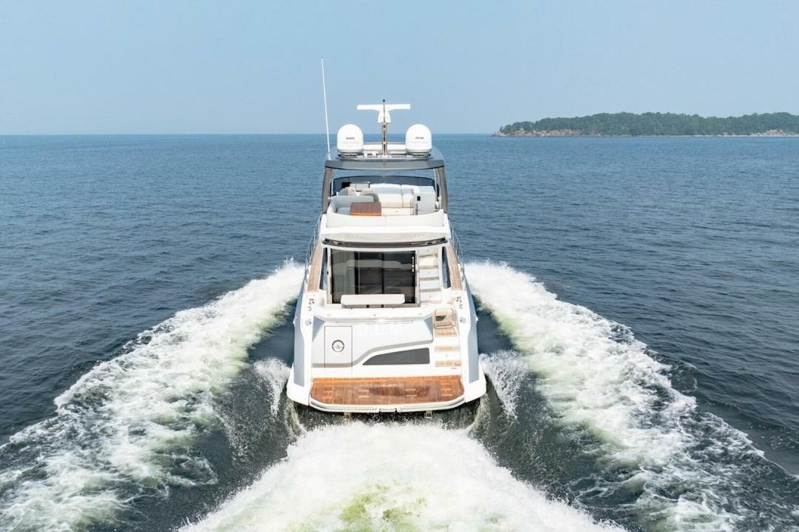 2023 Azimut Fly 53 yacht cruising on open water, rear view.