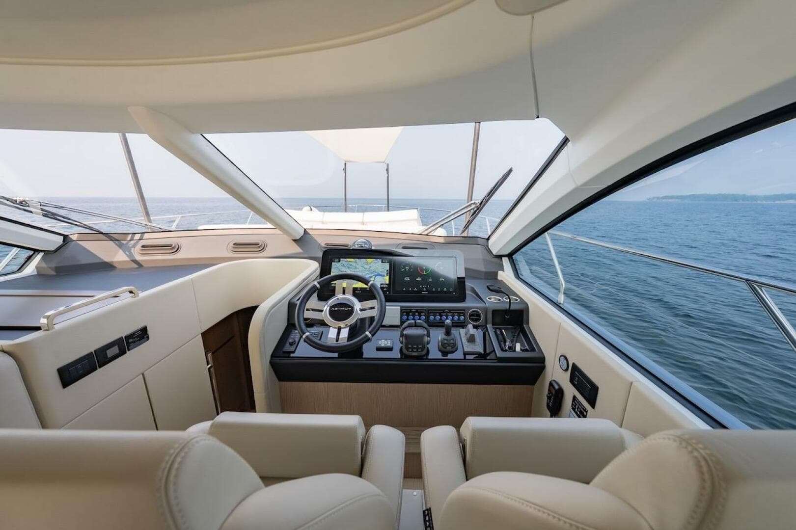 Luxurious interior of 2023 Azimut Fly 53 yacht with modern helm and ocean view.