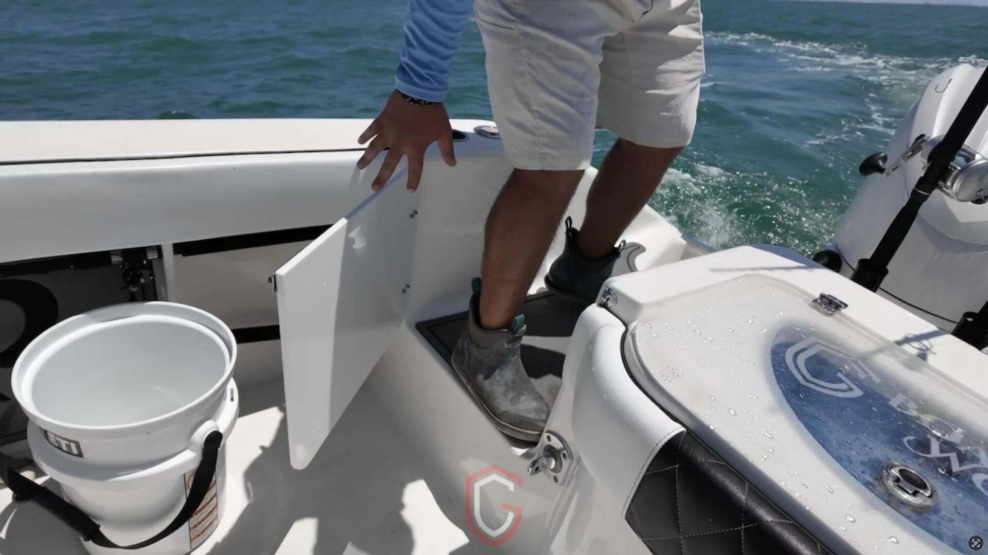 Person on 2023 CG Boat Works 35 M-Series, accessing storage compartment on deck.