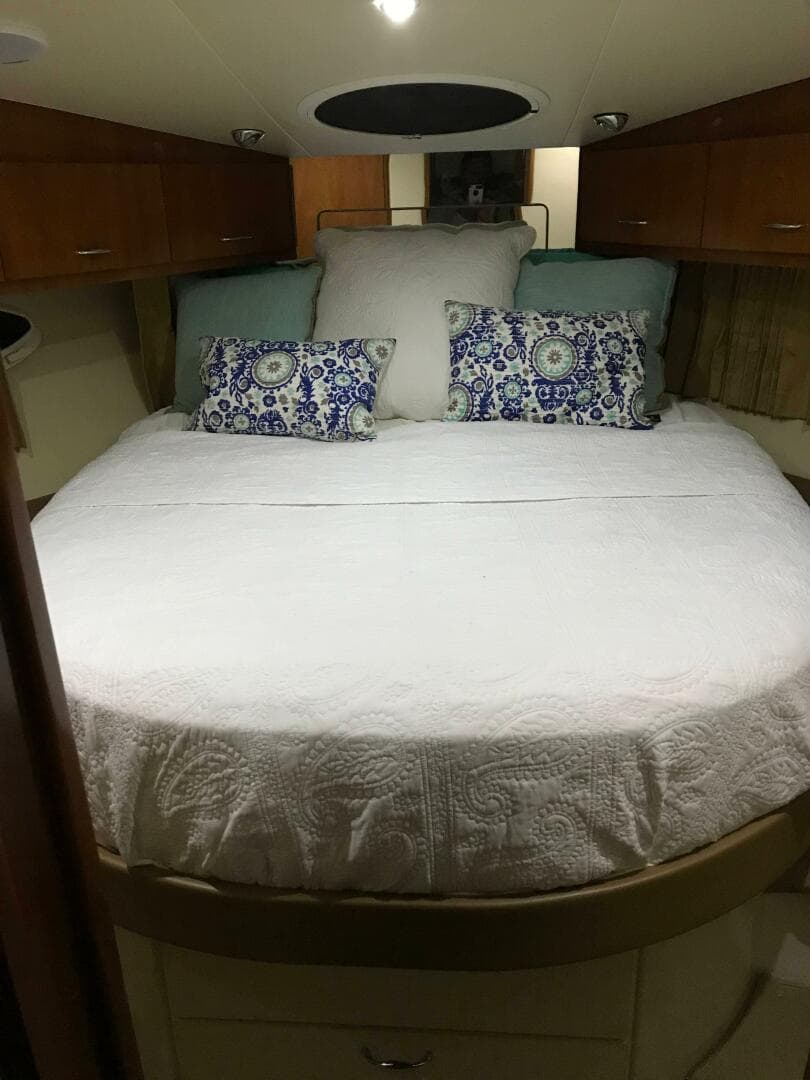 Luxurious bedroom interior of 2004 Carver 360 Sport Sedan with elegant bedding and wood cabinetry.