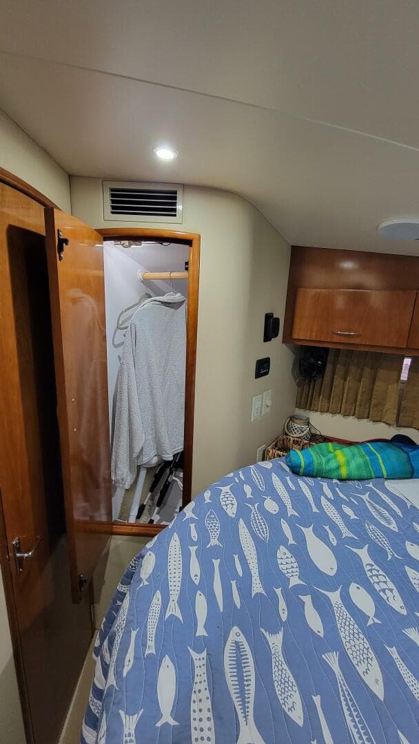 Interior of 2004 Carver 360 Sport Sedan with closet and fish-patterned bedspread.