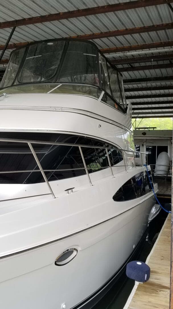 2004 Carver 360 Sport Sedan yacht docked in covered marina.