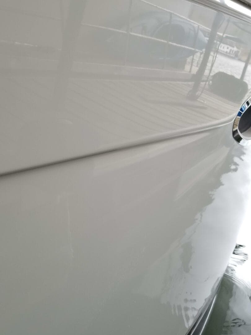 Close-up of a 2004 Carver 360 Sport Sedan boat hull reflecting water.